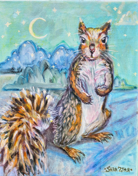 A sweet squirrel with a fluffy tall standing up and looking at the viewer